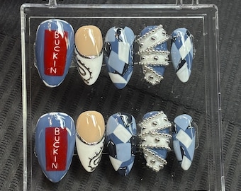 May include: A set of press-on nails in a clear plastic case. The nails feature various designs, including blue and white geometric patterns, silver bead accents, and nails with the word "BUCKIN" in red lettering.