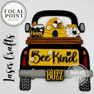 Könnte beinhalten: Ein schwarzes, holzgeschnitztes Schild in Form eines Trucks mit gelber Ladefläche, auf der "Bee Kind" steht. Die Ladefläche zeigt einen Bienenstock, ein Honigglas und eine Wabe. Das Schild hat auch das Wort "Buzz" und "Insert only."