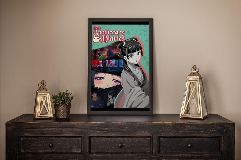 May include: Framed art print featuring anime-style artwork. The print showcases a female character with black hair and a traditional outfit, set against a teal background. The title "The Apothecary Diaries" is visible at the top. The artwork is displayed on a dark wooden surface.