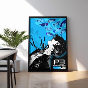 Puede incluir: Una impresión artística enmarcada con una ilustración de estilo anime. Muestra un personaje mirando hacia arriba, con rostros flotantes sobre un fondo azul. La impresión incluye el texto "P3 Persona 3 Reload" en blanco.