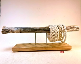 May include: A rustic wooden display stand featuring a natural driftwood beam supported by metal rods. Several cream-colored rope bracelets are displayed on the beam. The base is made of light-colored wood. The number "6002" is printed on the base.