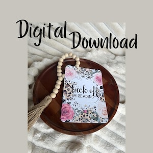 May include: A white card with a leopard print background and pink flowers. The text on the card reads "Tuck off I'm reading".