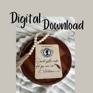 Puede incluir: Una bandeja de madera marrón con una guirnalda de cuentas blancas y una tarjeta con el texto "Lady Whistledown's Dearest gentle reader, did you miss me? L. Whistledown"
