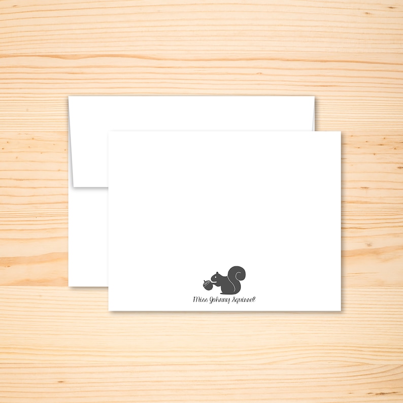 May include: A white card with a black silhouette of a squirrel holding an acorn. The text "Miss Johnny Squirrel" is printed below the squirrel.
