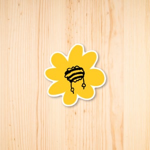 Può includere: Un fiore giallo con un'ape a strisce bianche e nere al centro.