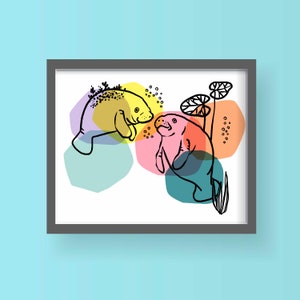 May include: A framed illustration of two manatees, one yellow and one pink, swimming in a colorful abstract background. The manatees are drawn in a simple, stylized way, and the background is made up of overlapping circles and shapes in various shades of blue, green, pink, and yellow.