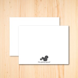 Puede incluir: Dos tarjetas blancas en blanco con una silueta de ardilla gris sosteniendo una bellota y el texto "Miss Johnny Squirrel" en la tarjeta inferior.