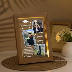 May include: A wooden picture frame with a light-up feature displays a collage of graduation photos. The frame has a gold border and the text "Class of 2025" and "Isabella Johnson" are visible. The text "So proud of the person you've become! Grateful I got a front-row seat. No matter where life takes you, save me a spot in your corner. Cheers to new beginnings!" is also visible.