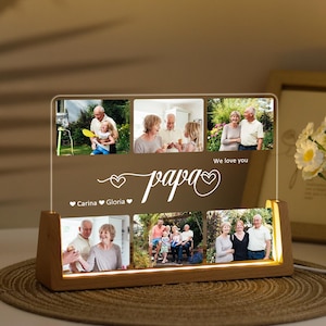 May include: A personalized photo display with the word "papa" in script, featuring family photos. The display has a wooden base with warm lighting and the text "We love you" and names. A thoughtful gift for Father's Day or a special occasion.