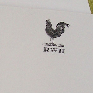 May include: A black and white illustration of a rooster standing on a striped base, with the letters "RWH" below. The rooster is detailed with textured shading, and the image is set against a white background.