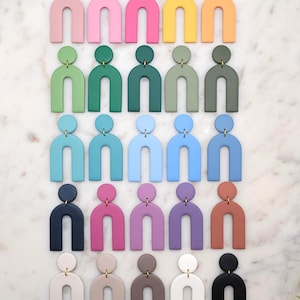 Peut inclure: Un ensemble de 30 paires de boucles d'oreilles en forme d'arche colorées. Les boucles d'oreilles sont en argile polymère et ont une finition mate. Les couleurs incluent le rose, le jaune, le vert, le bleu, le violet, le marron, le beige et le noir.