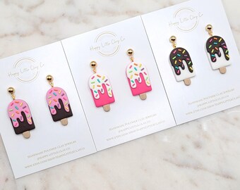 Puede incluir: Pendientes de paleta de arcilla polimérica en rosa, marrón y blanco con chispas de colores. Cada par se exhibe en una tarjeta blanca con el texto "Happy Little Clay Co" y "Handmade Polymer Clay Jewelry".