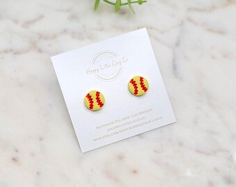 Peut inclure: Une paire de boucles d'oreilles en forme de balle de softball jaunes et rouges sur une carte blanche avec le texte "Happy Little Clay Co." et l'adresse du site Web "www.etsy.com/shop/happylittleclayco".