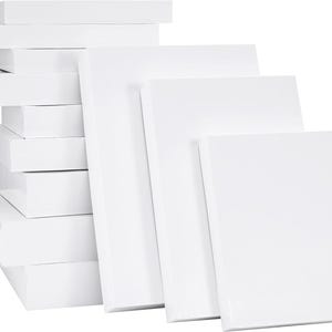 Puede incluir: Una colección de lienzos de artista blancos y tableros de lienzo estirados. Los lienzos son de varios tamaños y están apilados. Las superficies blancas están limpias y listas para pintar u otros proyectos artísticos.