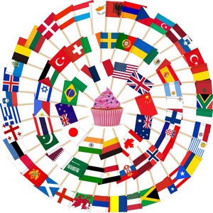May include: A cupcake with pink frosting and blueberries is surrounded by a circular arrangement of miniature flags representing various countries. The flags are attached to wooden sticks, creating a festive and celebratory display.