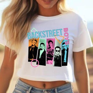 Puede incluir: Top corto blanco con un gr&aacute;fico colorido de los Backstreet Boys. El dise&ntilde;o incluye el nombre de la banda e im&aacute;genes de los miembros. La camiseta es de material blanco Bella+Canvas.