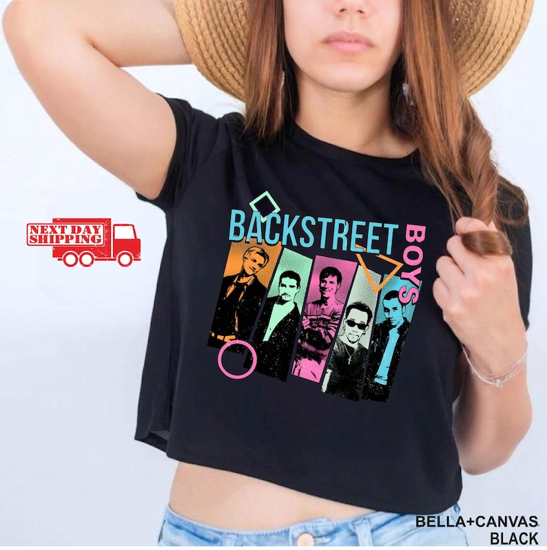Puede incluir: Top corto negro con el texto "BACKSTREET BOYS" en verde azulado y naranja, y un gr&aacute;fico de los miembros de la banda. La camiseta est&aacute; hecha de material de lona negra.
