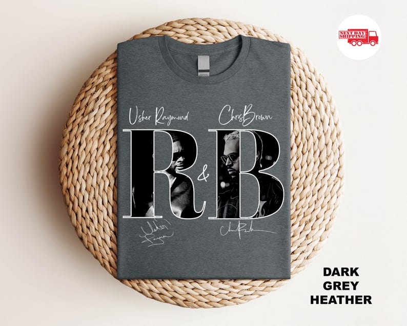 May include: Dark grey heather t-shirt featuring the text "Usher Raymond & Chris Brown R&B" in white. The shirt has black and white images of the artists. The words "Dark Grey Heather" are printed on the bottom right.