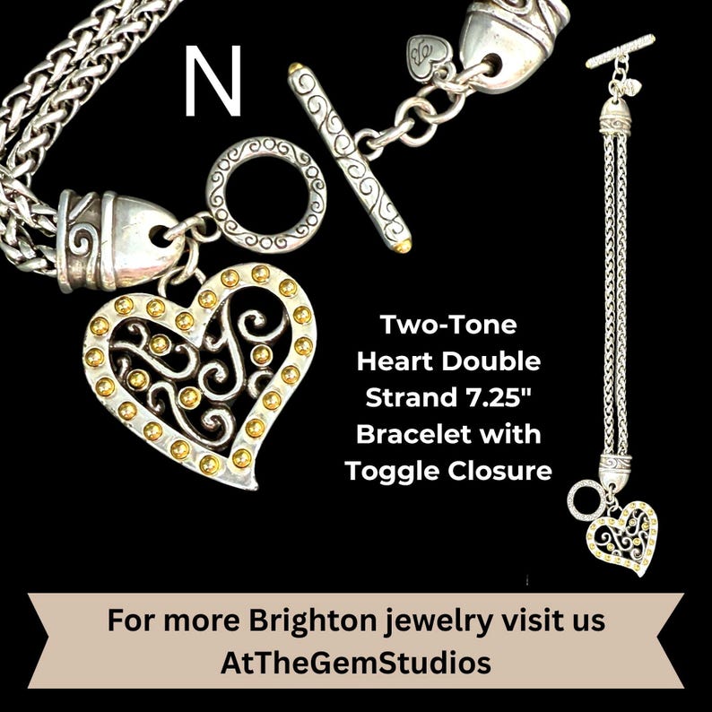 May include: A two-tone heart bracelet with a toggle closure. The bracelet has a double strand design and is 7.25 inches long. The heart charm is silver with gold accents. The text "Two-Tone Heart Double Strand 7.25" Bracelet with Toggle Closure" is visible.
