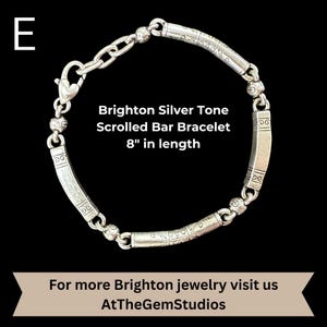 May include: Brighton silver tone scrolled bar bracelet, 8 inches in length. The bracelet features a series of curved, engraved bars connected by smaller, decorative links. The clasp is a heart-shaped lobster claw. The text "Brighton Silver Tone Scrolled Bar Bracelet 8" in length" is visible.