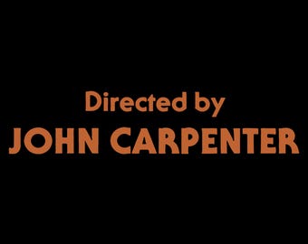 Può includere: Uno sfondo nero con il testo "Directed by JOHN CARPENTER" in arancione.