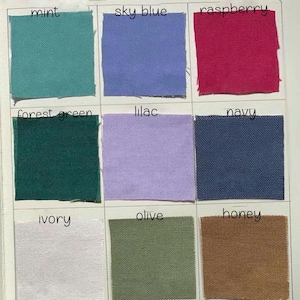 May include: A color swatch card featuring nine fabric samples in various colors. The colors include mint, sky blue, raspberry, forest green, lilac, navy, ivory, olive, and honey. Each swatch is labeled with its corresponding color name in black text.