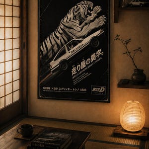 Può includere: Un poster da parete rettangolare con un'illustrazione in bianco e nero di una tigre che salta sopra una Toyota Sprinter Trueno AE86 bianca. Il poster include testo in giapponese, la frase in inglese This is where the legend begins e 1983 Toyota Sprinter Trueno AE86.