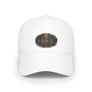 May include: White baseball cap with a black and gold emblem featuring the year 1965.