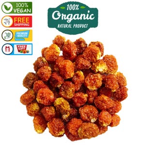 Może przedstawiać: Stos suszonych, pomarańczowo-brązowych organicznych jagód. Obraz zawiera tekst "100% Organic Natural Product", "100% Vegan", "Free Shipping", "Premium Quality" i "Free Gift".