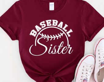 May include: Burgundy t-shirt with white text that reads "Baseball Sister" and a white baseball graphic.