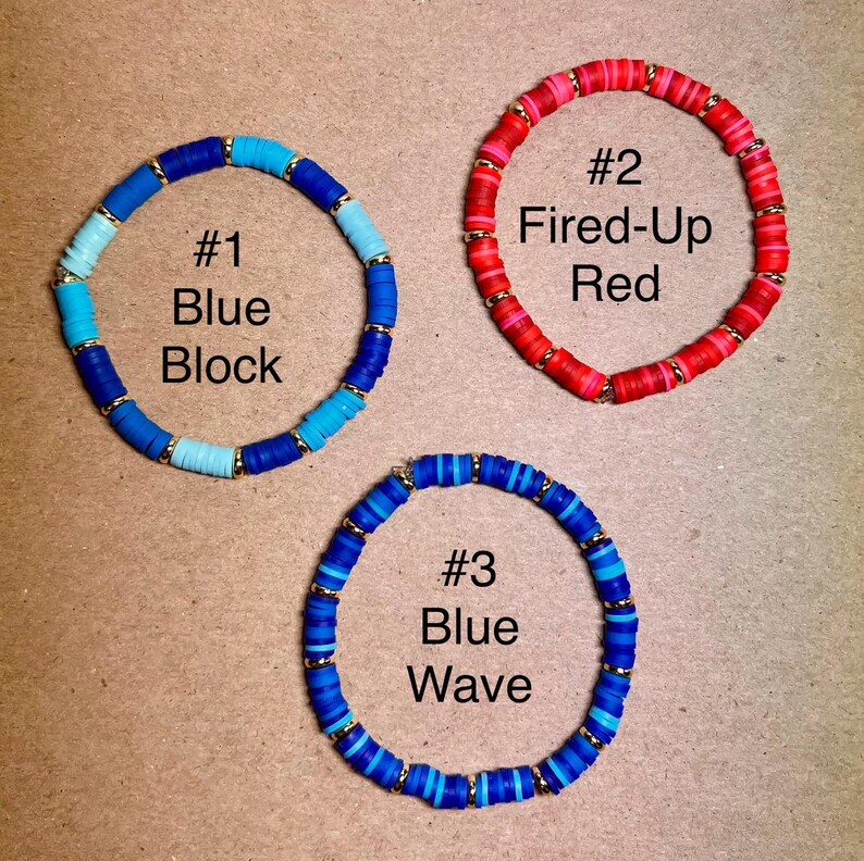 May include: Three beaded bracelets in shades of blue and red. The bracelets are labeled "#1 Blue Block", "#2 Fired-Up Red", and "#3 Blue Wave". Each bracelet features a mix of colors and gold-colored accents.