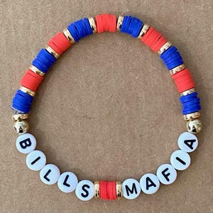 May include: A red, white, and blue beaded bracelet with the words "Bills Mafia" spelled out in white letters on the beads.