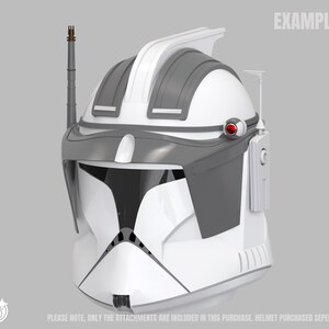 May include: A white and grey helmet with a visor, antenna, and communication device. The helmet has a red accent and the word "EXAMPLE" is printed on the top right. The text at the bottom says, "PLEASE NOTE, ONLY THE ATTACHMENTS ARE INCLUDED IN THIS PURCHASE. HELMET PURCHASED SEPERATELY."