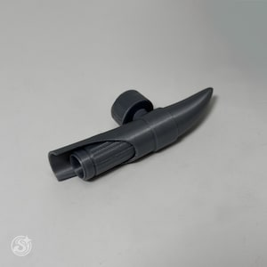 Puede incluir: Un aireador de vino gris, impreso en 3D, con un cuerpo cilíndrico y un pico puntiagudo. El aireador incluye una pequeña tapa redonda y un interior acanalado. El diseño es moderno y elegante.