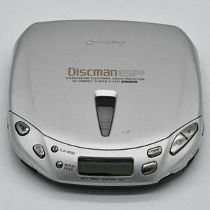 May include: Silver Sony Discman ESP2 CD player. Features include SteadySound Electronic Shock Protection, a digital display, and control buttons. The text "Discman ESP2" is printed on the device.
