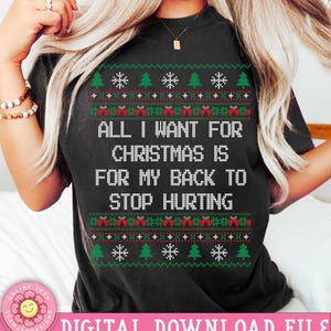 Könnte beinhalten: Schwarzes T-Shirt mit einem rot-grünen Weihnachtspullover-Design. Der Text auf dem Shirt lautet "Alles, was ich mir zu Weihnachten wünsche, ist, dass mein Rücken aufhört zu schmerzen."
