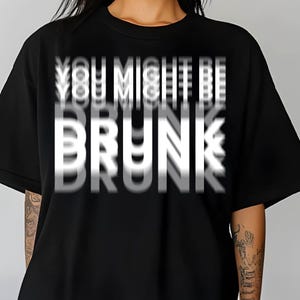May include: Black t-shirt with the text "YOU MIGHT BE BRUNK" in a blurred white font. The shirt is a crew neck style and appears to be made of a soft material.