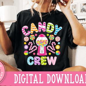 May include: A black t-shirt with a colorful graphic design featuring a gumball machine, candy canes, and lollipops. The text "Candy Crew" is printed on the shirt.