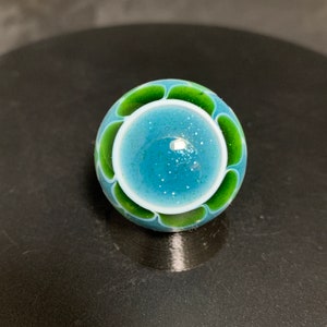 27.4mm handmade sparkly blue and green dotstack mandala with silver and gold fumed interior.
