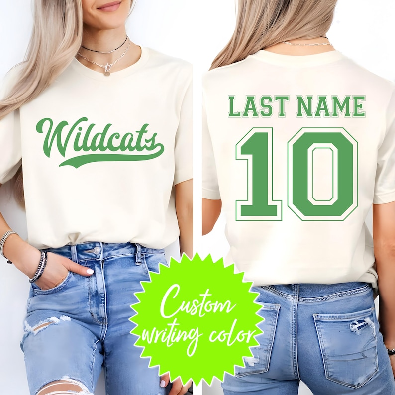 Puede incluir: Camiseta color crema con la palabra "Wildcats" en verde en la parte delantera. La parte trasera muestra "LAST NAME" sobre el n&uacute;mero "10" en verde. La imagen tambi&eacute;n incluye un gr&aacute;fico verde ne&oacute;n que dice "Custom writing color".