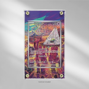 May include: A Drowzee Pokémon card in a clear acrylic case. The card features a colorful illustration of a carnival scene with a Ferris wheel and a tent. The card is labeled with the name "Drowzee" and has text at the bottom.