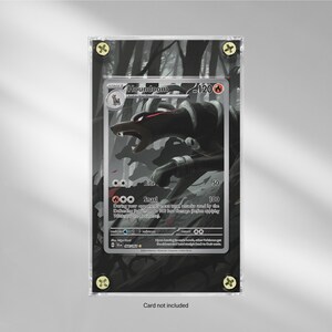 Könnte beinhalten: Eine gerahmte Houndoom-Pokémon-Karte. Die Karte zeigt eine schwarz-rote Illustration des Pokémon Houndoom. Die Karte ist in einem transparenten Acrylrahmen mit goldfarbenen Schrauben eingeschlossen. Der Hintergrund ist eine Graustufen-Waldszene.