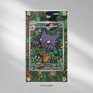 May include: A framed Haunter Pokémon trading card. The card features a purple Haunter character with a spooky shot attack. The frame has a green and brown forest design with mushrooms and the text "Card not included".