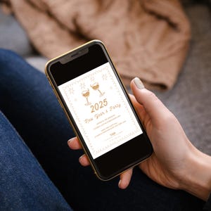 Puede incluir: Un tel&eacute;fono inteligente que muestra una invitaci&oacute;n a una fiesta de Nochevieja con un dise&ntilde;o dorado y blanco. La invitaci&oacute;n presenta dos copas de champ&aacute;n y el texto "2025 Fiesta de A&ntilde;o Nuevo".