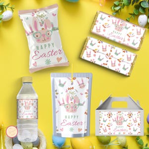 Puede incluir: Un conjunto de favores de fiesta de Pascua con un diseño de conejo. El conjunto incluye una bolsa de patatas fritas, una caja de jugo, una botella de agua, una barra de chocolate y una caja de regalo. Todos los artículos presentan un conejo rosa y verde con el texto "Feliz Pascua".