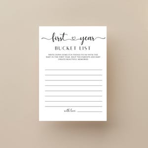 Może przedstawiać: Drukowana karta do gry na baby shower z tekstem "first year BUCKET LIST" i instrukcjami, aby zapisać zabawne rzeczy do zrobienia z dzieckiem w pierwszym roku. Karta zawiera symbol serca między słowami "first" i "year".