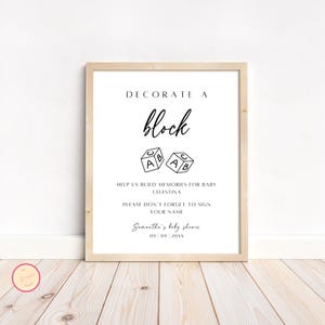 Könnte beinhalten: Ein schwarz-weißes druckbares Schild mit der Aufschrift "Dekoriere einen Block" mit zwei Illustrationen von Alphabetblöcken. Das Schild enthält auch den Text "Hilf uns, Erinnerungen für Baby Celestina zu schaffen. Vergiss bitte nicht, deinen Namen zu unterschreiben. Samanthas Babyparty 09 09 20XX".