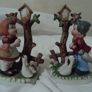 Vintage ceramic figurine Hummelesque LIttle boy and girl  birdhouses in trees picnic basket and rainy day umbrella pet geese by their side