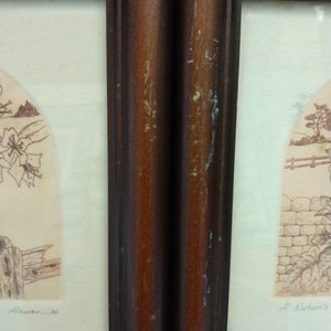 Op de afbeelding: Twee ingelijste prints met bruine houten lijsten. De prints zijn in zwart-wit en tonen een sc&egrave;ne met een hek en een bloem aan de linkerkant en een stenen muur en een boom aan de rechterkant. De prints zijn gesigneerd met "Allaman" en "of Nature's".