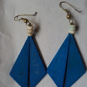 May include: A pair of blue wooden earrings with white beads and gold hooks.